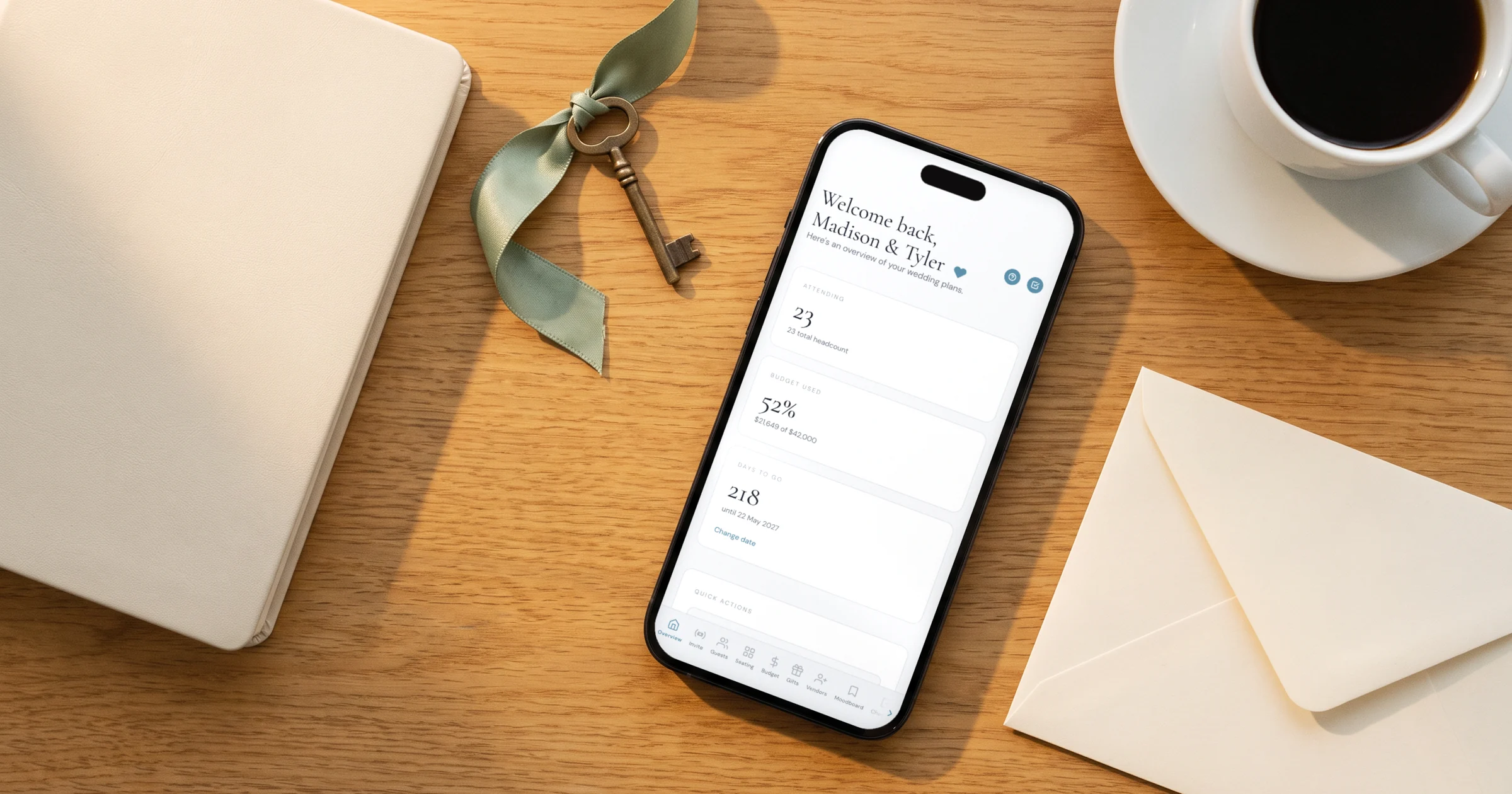 The Private Wedding App lifetime plan: a phone shows the wedding planning dashboard, next to a wedding planner notebook and a brass key on a ribbon