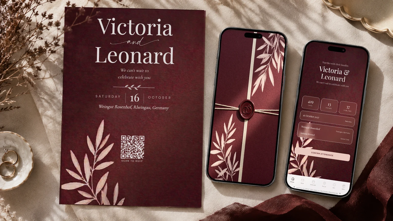 Burgundy wedding invitation on a phone beside a printed QR card, showing the burgundy, wine, blush and foliage palette